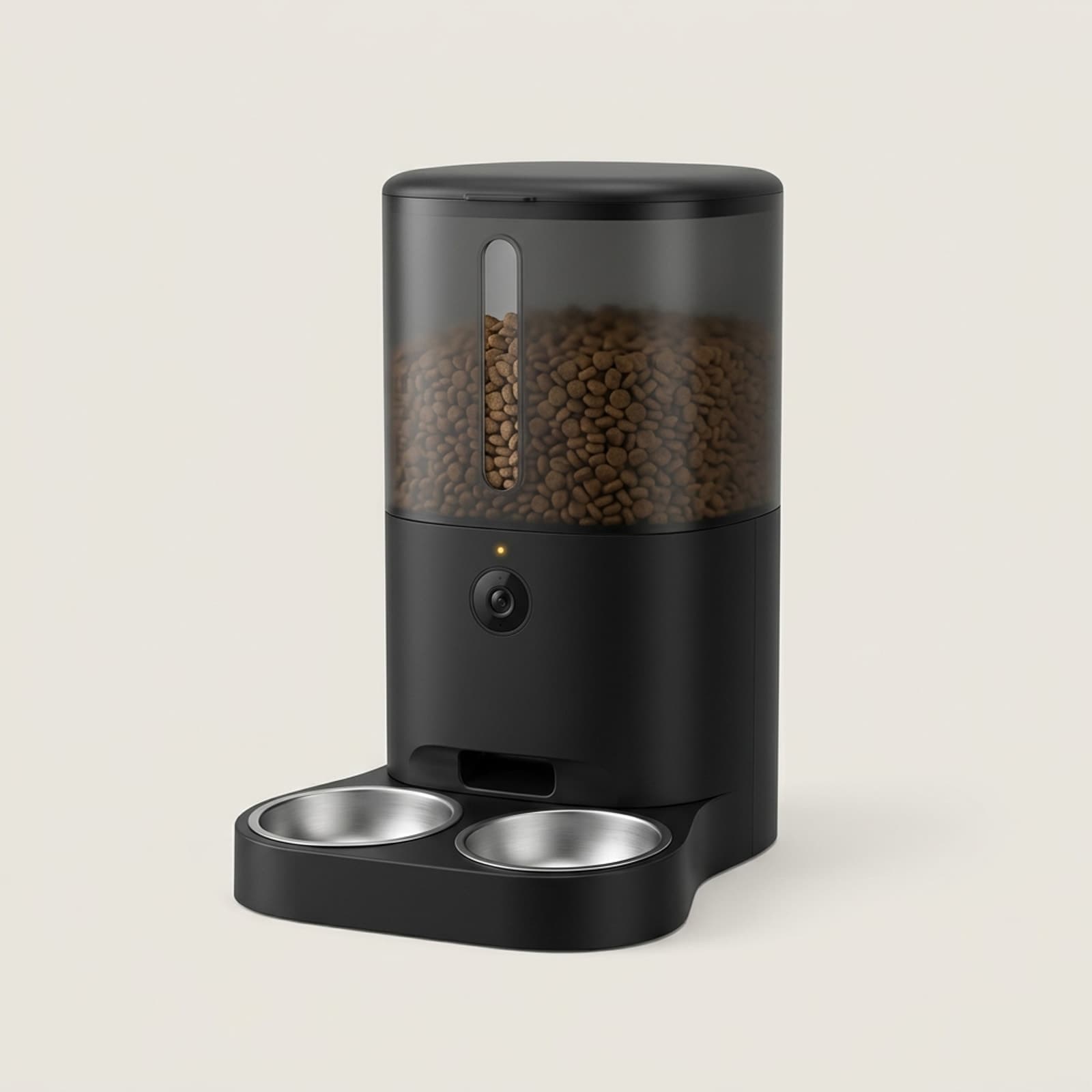 Distributeur de croquettes noir avec caméra intégrée et double gamelle inox, croquettes visibles dans le réservoir, sur fond ivoire